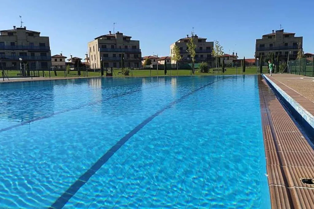 Piscina comunitaria de la urbanización con bloques al fondo