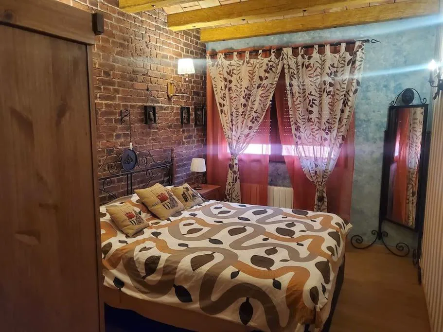 Dormitorio con cabecero de madera y cortinas rojas