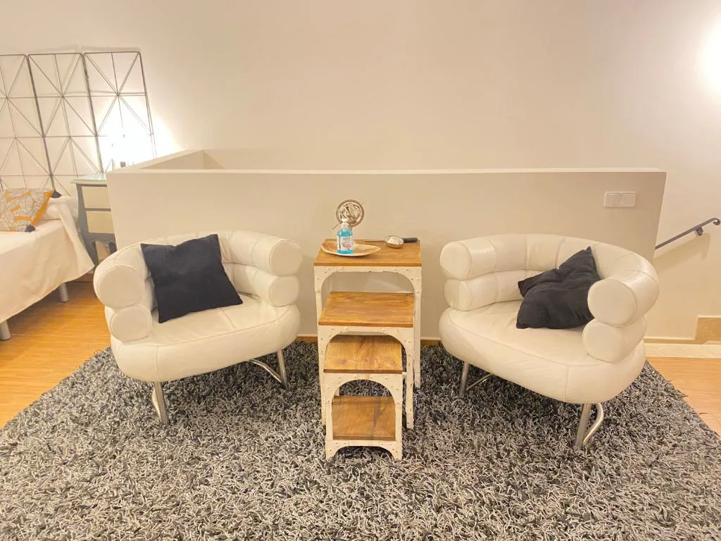 Sala de estar con sillones blancos y alfombra