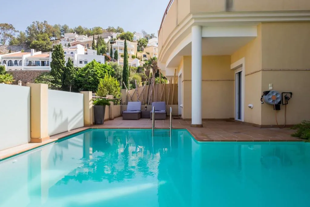 Casa con piscina turquesa y terraza con vistas a la montaña