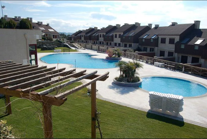 Vista de las piscinas comunitarias del complejo entre los adosados y jardines