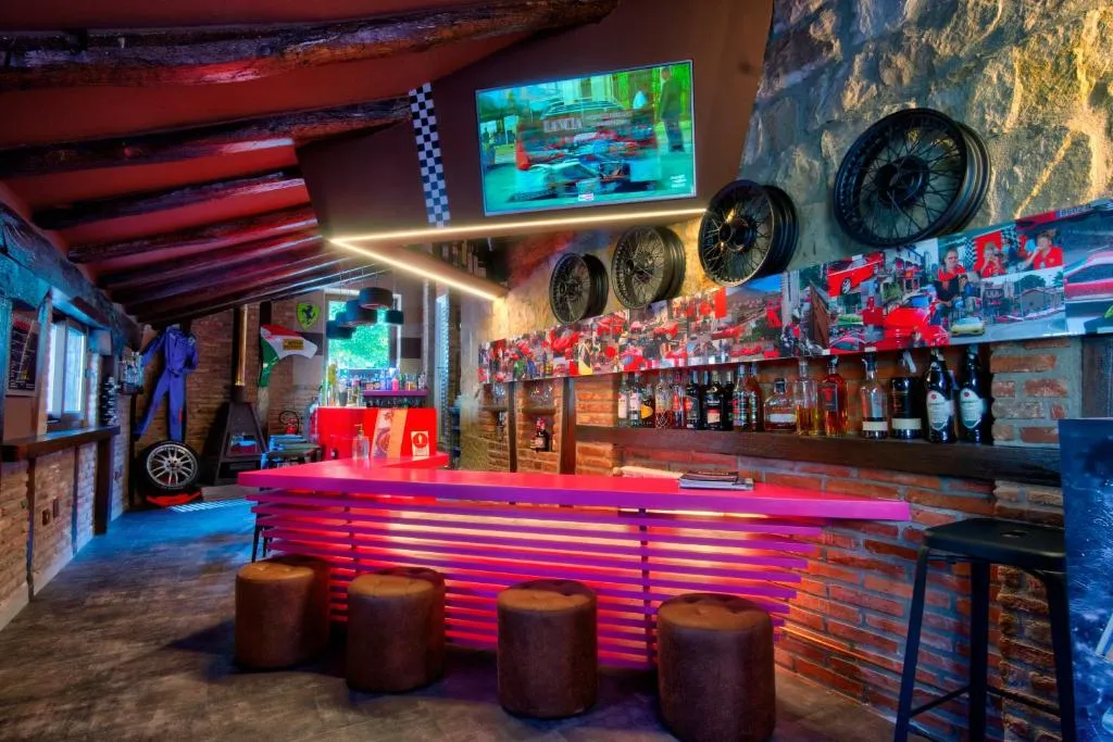 Bar temático de motor con barra iluminada en rojo y recuerdos de Fórmula 1, uno de los rincones con más carácter del hotel
