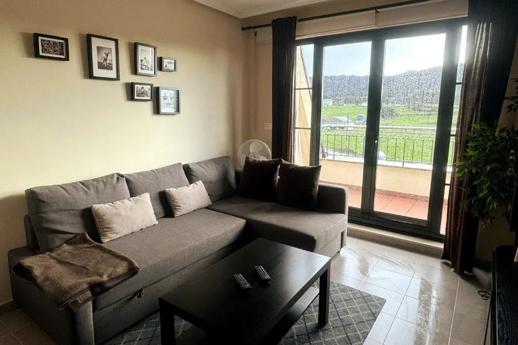 Salón con sofá y puerta acristalada a la terraza con vistas al monte, Costa SPA Ático de lujo