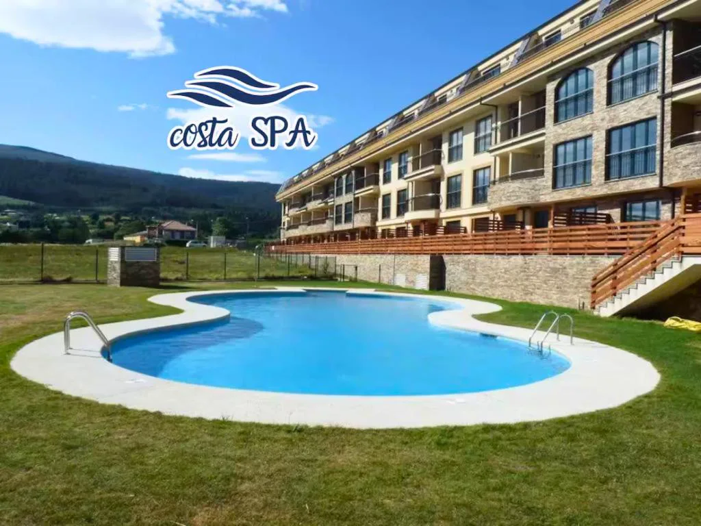Piscina exterior con jardín, junto al edificio de apartamentos del complejo Costa SPA