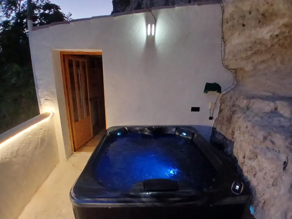 Jacuzzi oscuro con luz azul bajo la roca