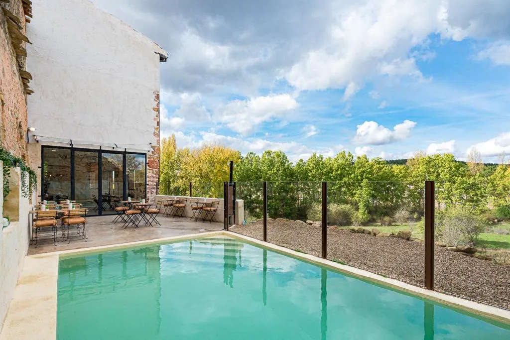 Piscina rectangular con el pueblo de piedra al fondo