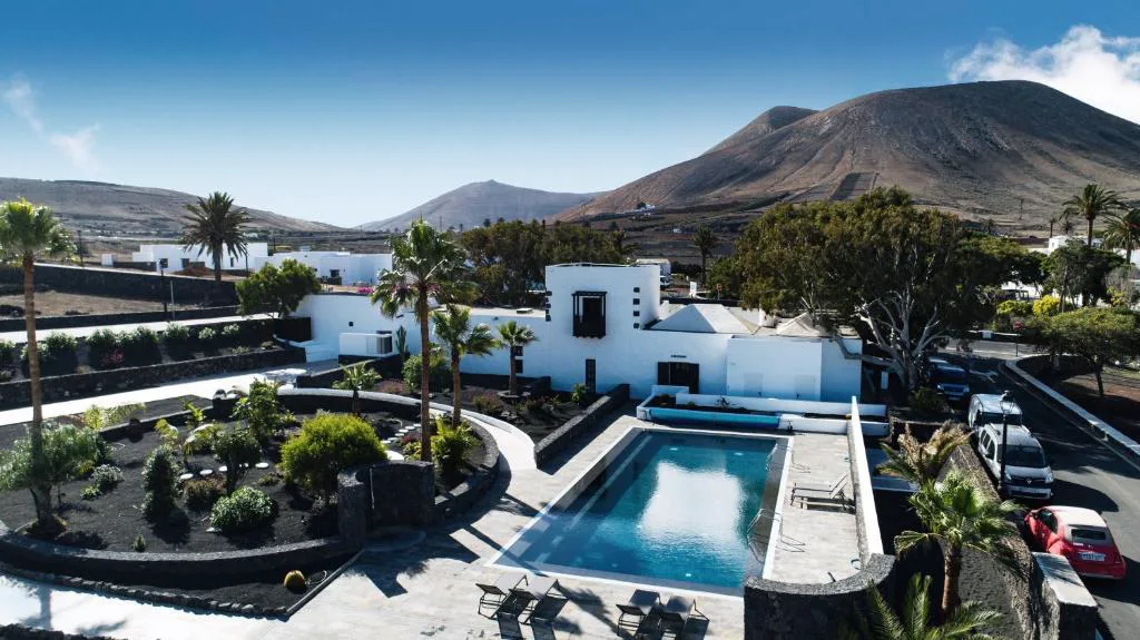 Vista aérea de Eco-Finca Curbelo con piscina y volcanes de fondo, en Uga, Lanzarote