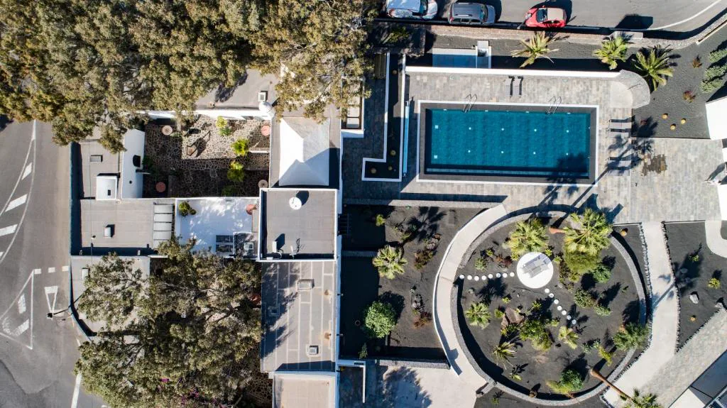 Vista aérea cenital de la piscina rectangular y el jardín volcánico, Eco-Finca Curbelo