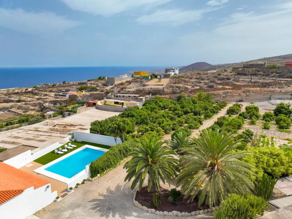 Vista aérea de la finca con piscina, huerto de cítricos y el mar al fondo, Eco-Finca Güímar