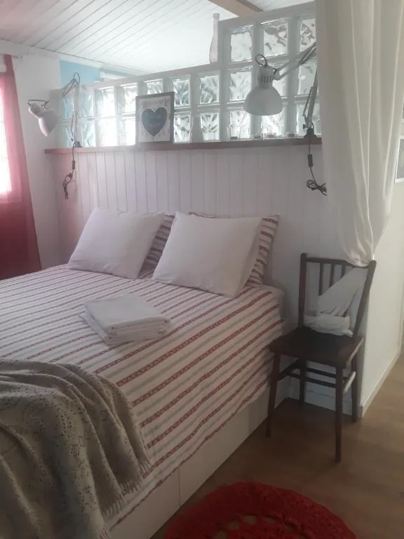 Habitación abuhardillada con cabecero de madera y detalles en rojo, El Atico de Villalmar