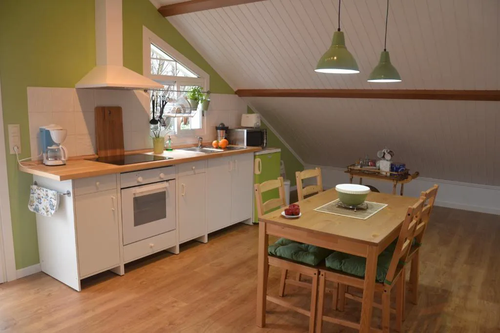 Cocina abuhardillada equipada en tonos verdes y blancos, El Atico de Villalmar