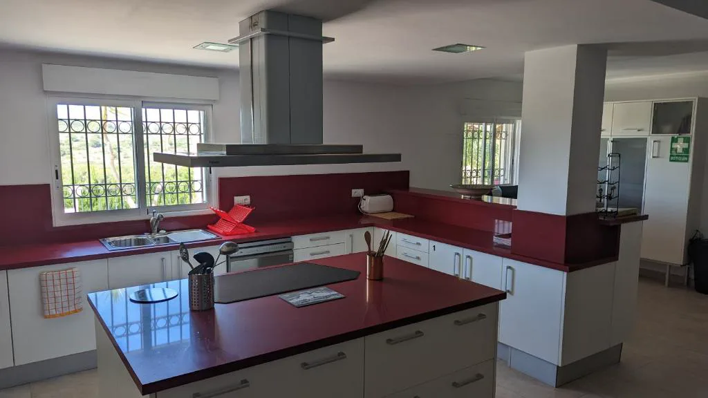 Cocina amplia con isla y encimera roja