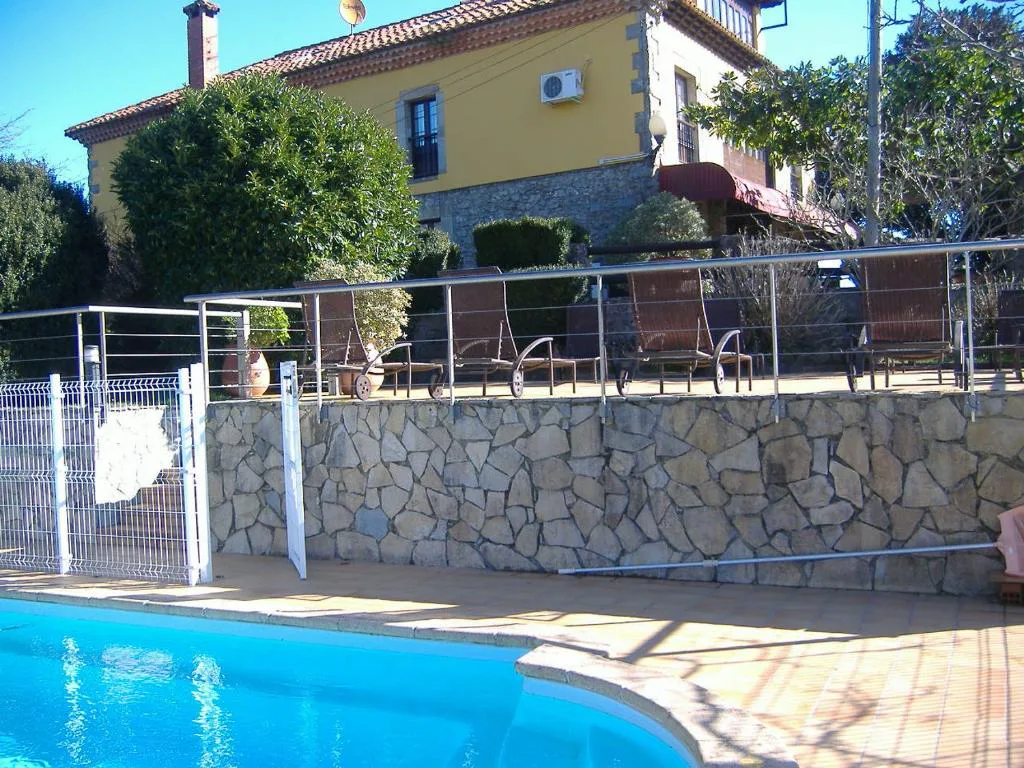Piscina y muro de piedra con barandilla