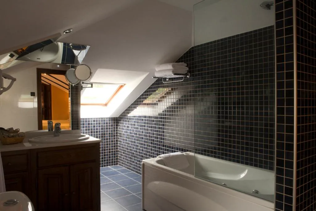 Baño abuhardillado con bañera de hidromasaje y pared de pizarra