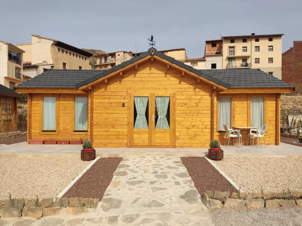 Cabaña de madera con puerta y jardín de piedra
