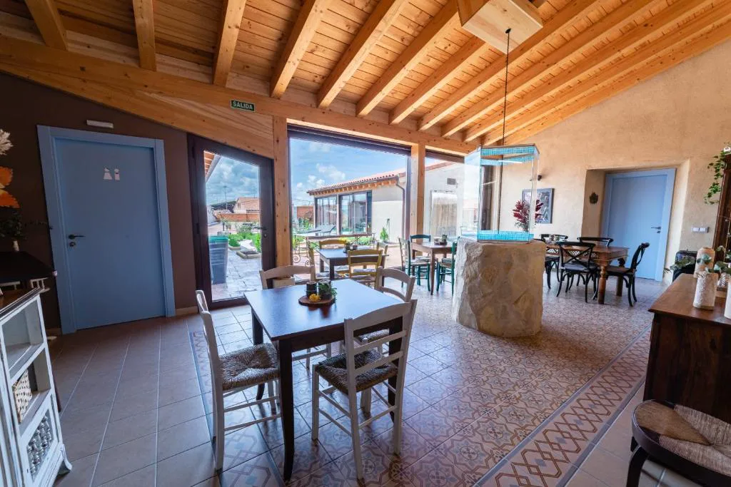 Comedor con vigas de madera y cristaleras al jardín