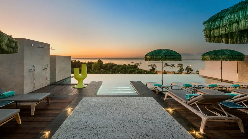Piscina infinita en la azotea de El Llorenç Parc de la Mar al atardecer, con vistas a la bahía de Palma