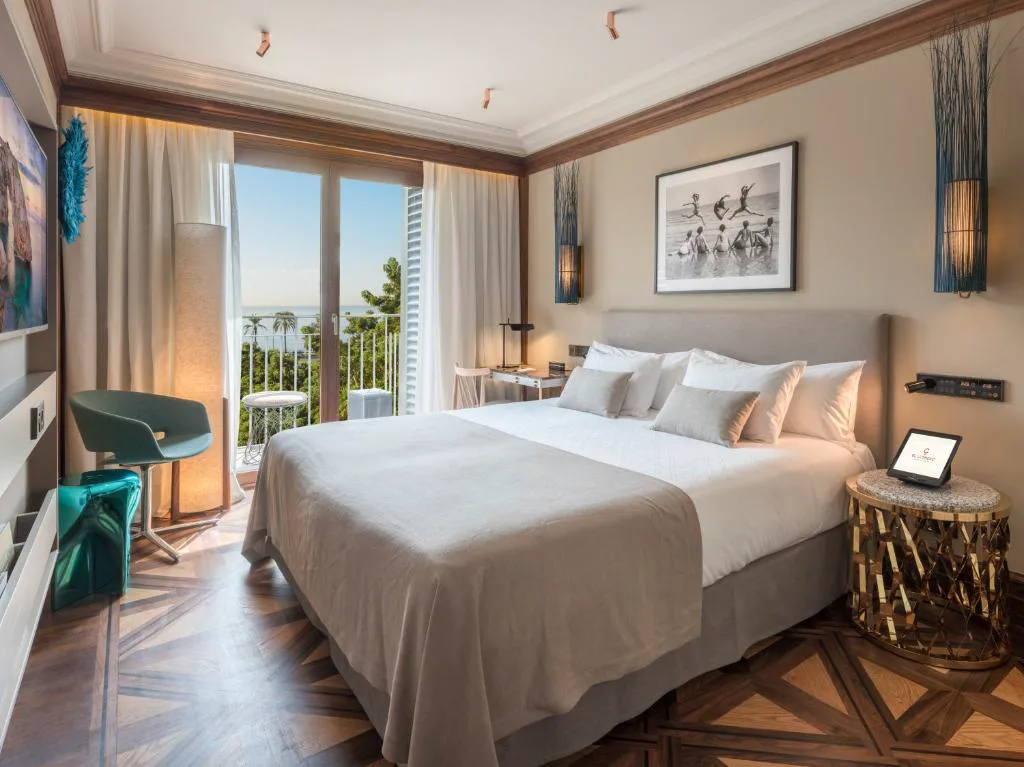 Dormitorio con balcón abierto al mar y suelo de parqué geométrico, El Llorenç Parc de la Mar