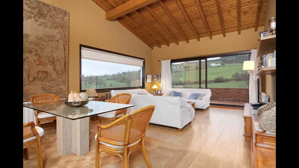 Salón con ventanal panorámico y techo de madera