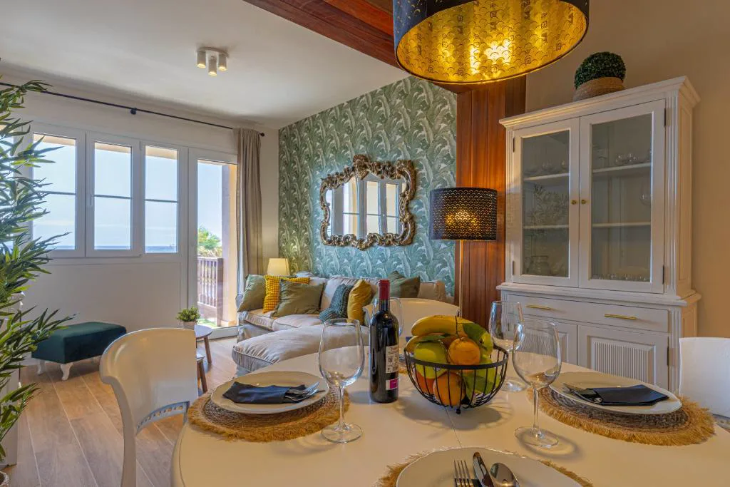 Mesa de comedor puesta con vistas al mar a través de las cristaleras, El Mirador de Julia