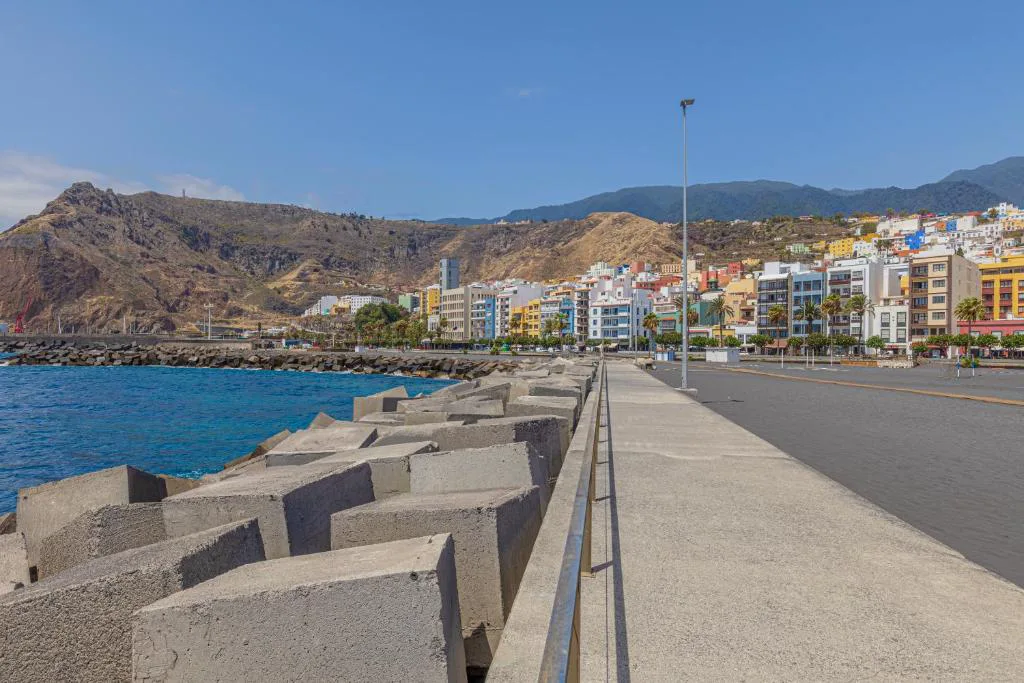 Paseo marítimo con bloques de hormigón y las fachadas de colores de Santa Cruz de la Palma al fondo