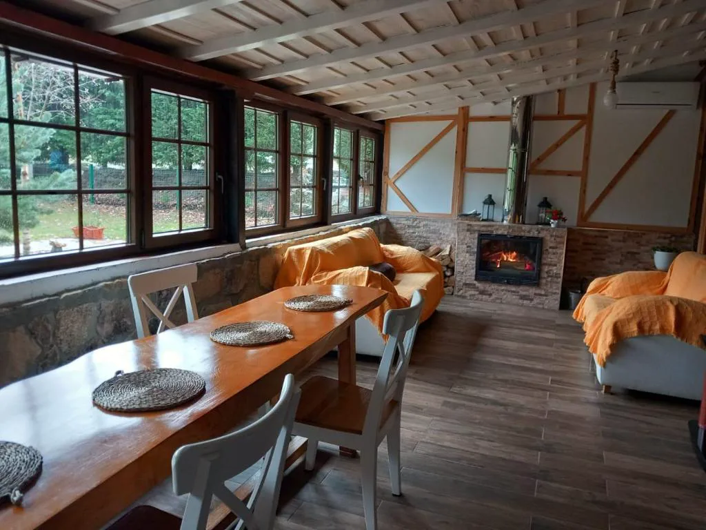 Salón acristalado con chimenea y mesa de madera