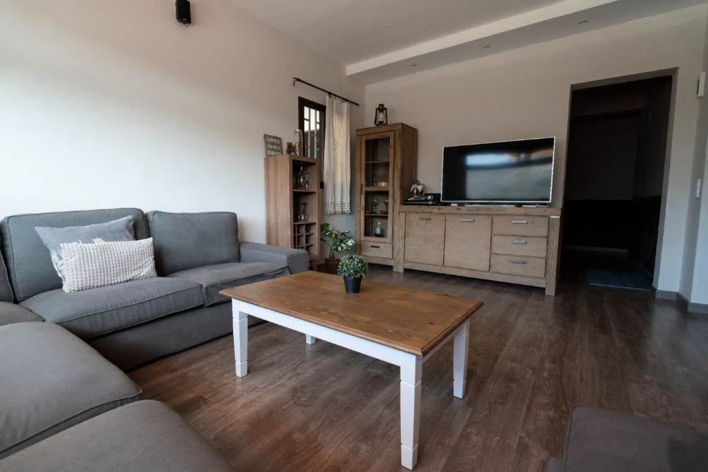 Salón con sofás grises y televisor de pantalla plana, El Recoveco de La Solana