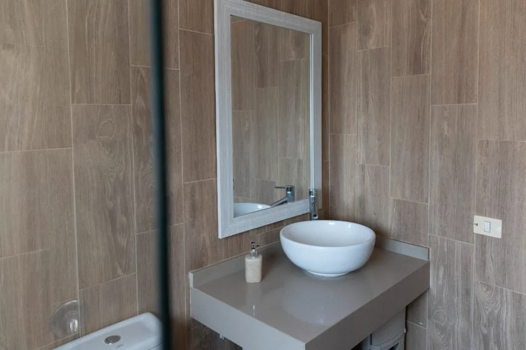 Baño con lavabo de sobre bol y espejo enmarcado en blanco, El Recoveco de La Solana