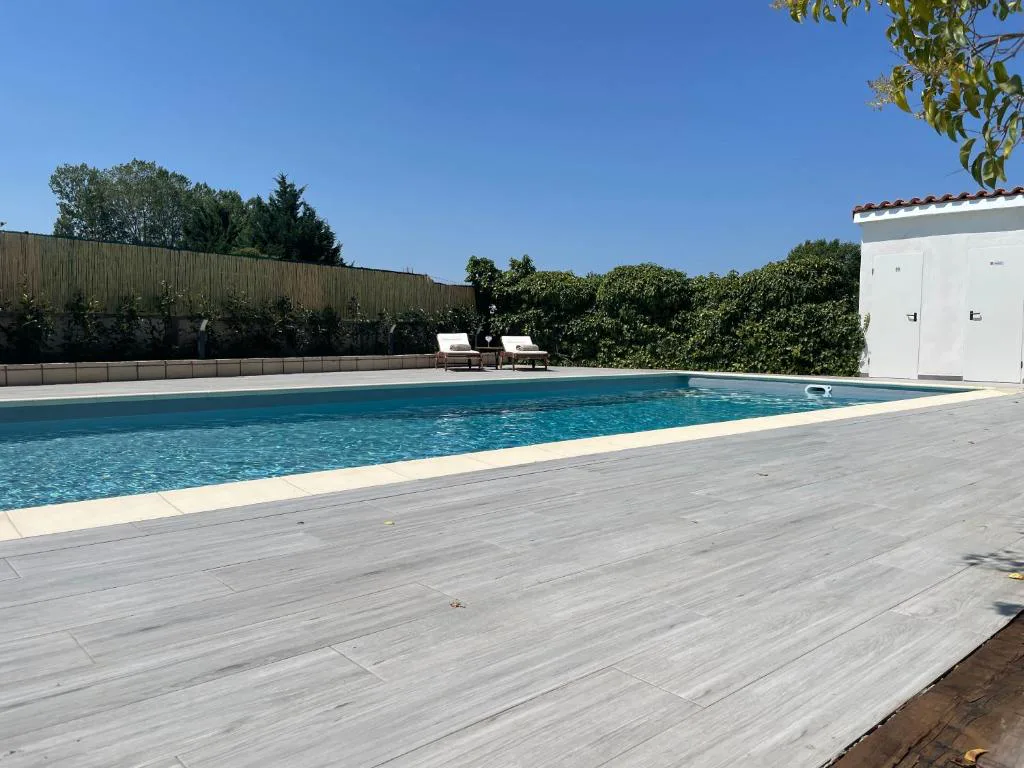 Piscina larga con solárium de madera