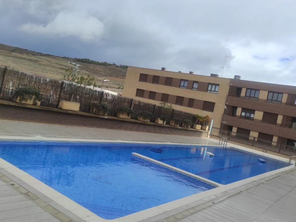Piscina comunitaria azul en un patio con bloques de viviendas