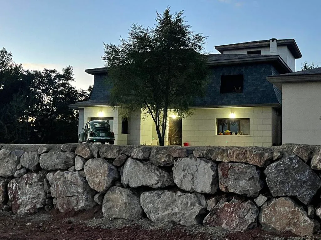 Casa entre muros de piedra al anochecer