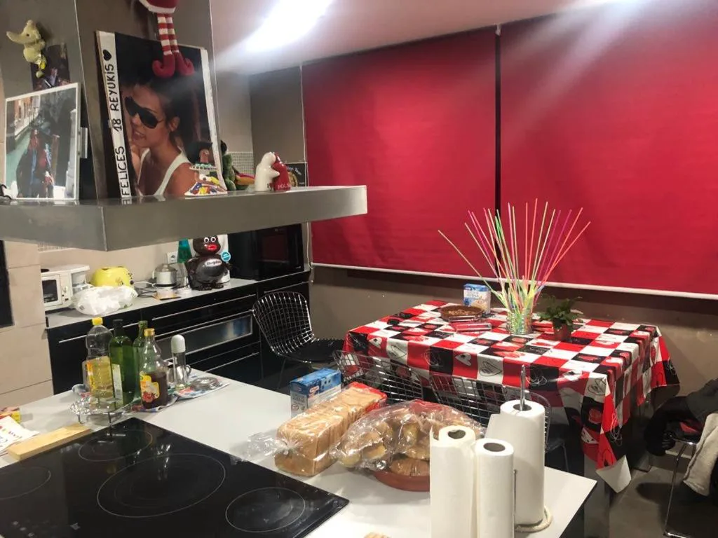 Cocina con mesa redonda y mantel rojo