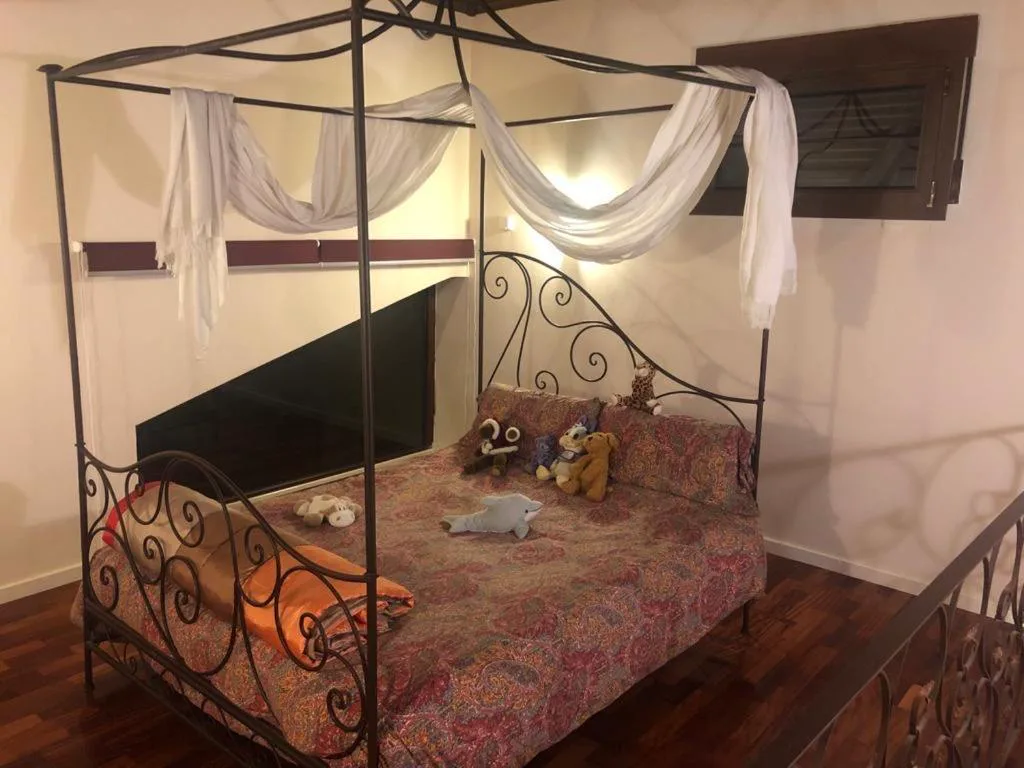 Habitación con cama de forja y mosquitero