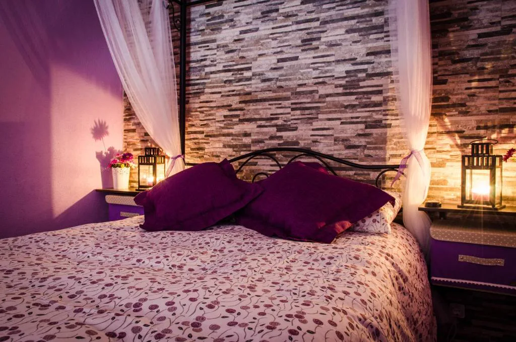 Habitación con dosel y pared de piedra
