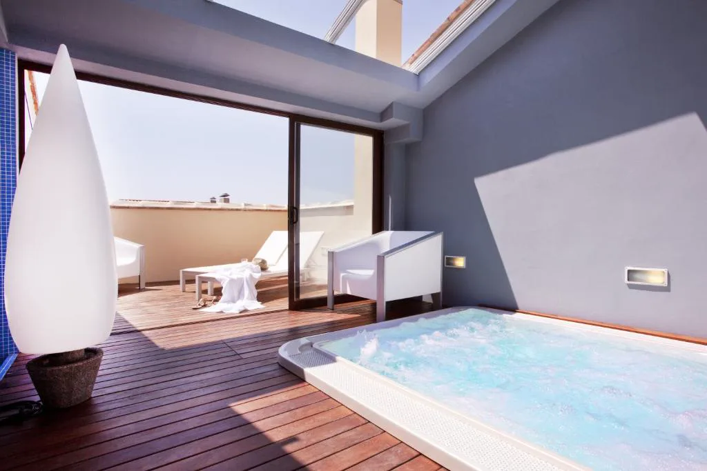 Habitación con un jacuzzi hundido en el suelo junto a la cama