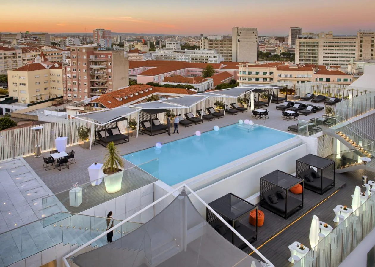 Piscina infinita en la azotea de EPIC SANA Lisboa al atardecer, con vistas a la ciudad