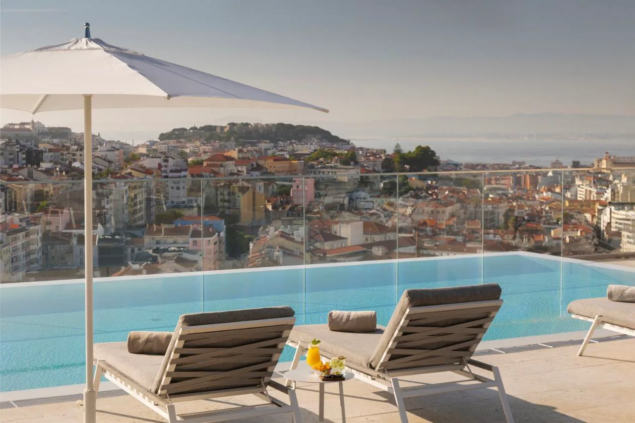 Piscina infinita en la azotea de EPIC SANA Marquês con vistas al Castelo de São Jorge y el Tajo
