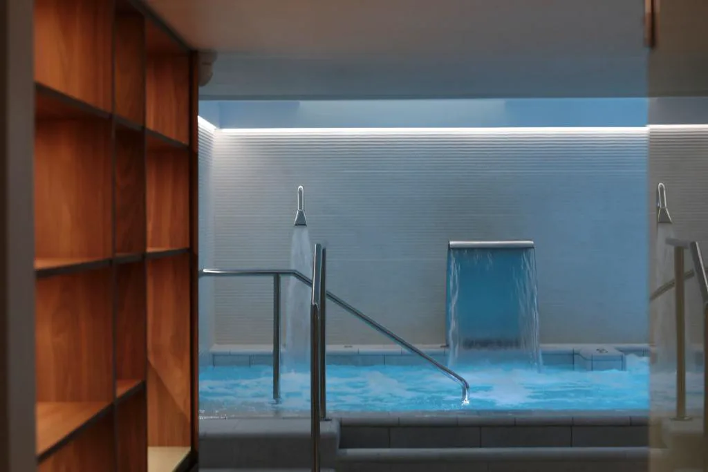 Piscina interior del spa con cascada de agua y velas, Es Princep