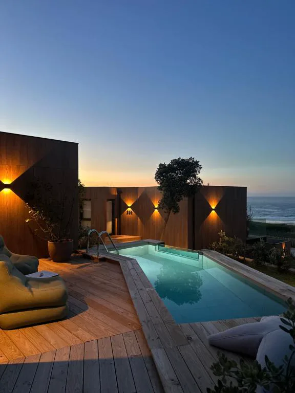 Piscina privada con iluminación al atardecer y vistas al mar, Espazo Nature