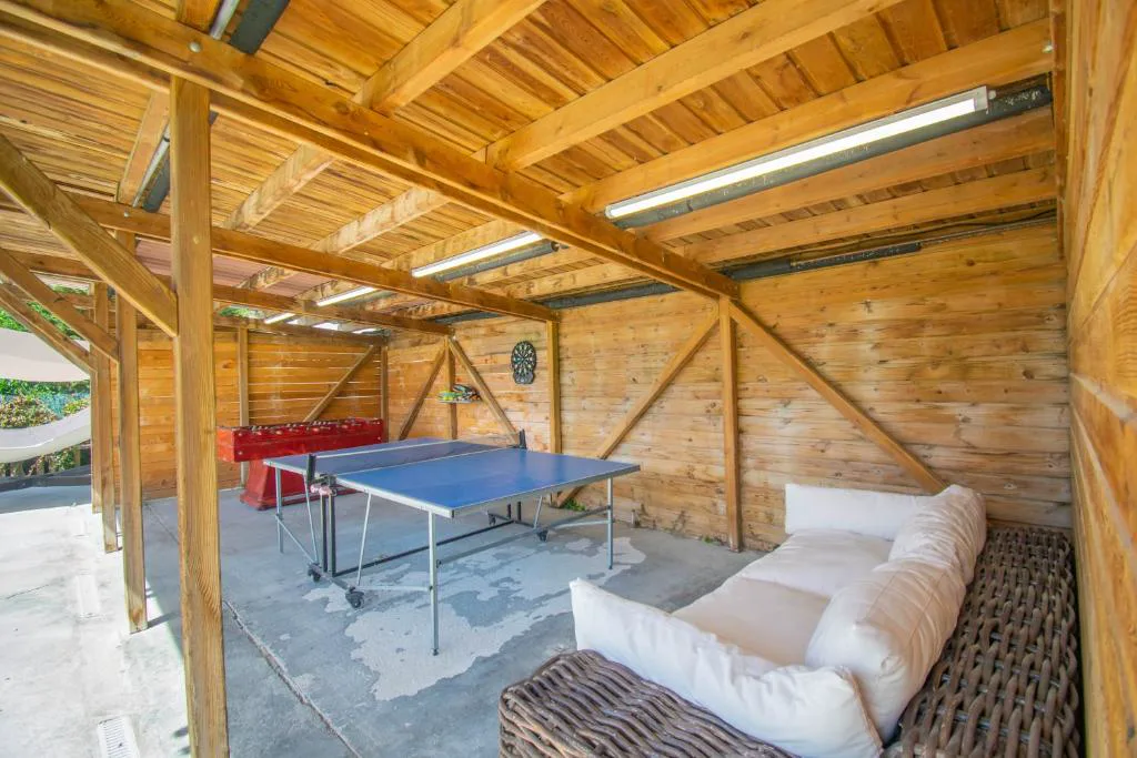Sala con mesa de ping pong bajo vigas de madera