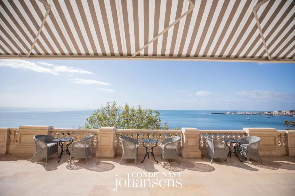 Terraza porticada con mesas y piscina con vistas al Atlántico, Estoril Vintage Hotel