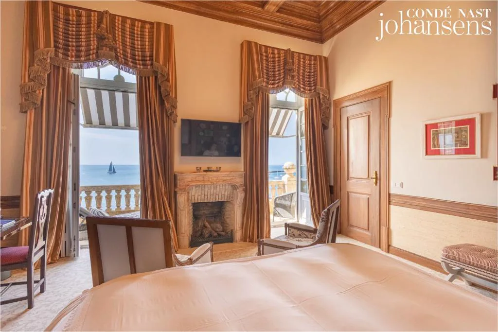 Suite con chimenea de mármol y vistas al mar desde la cama, Estoril Vintage Hotel