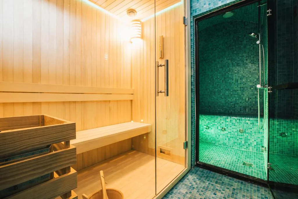Sauna de madera junto a la ducha de vapor en mosaico verde, Estoril Vintage Hotel