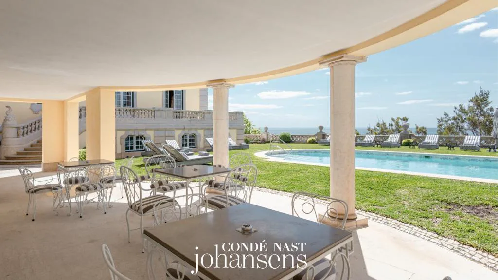 Terraza porticada con vistas a la piscina y al jardín frente al mar