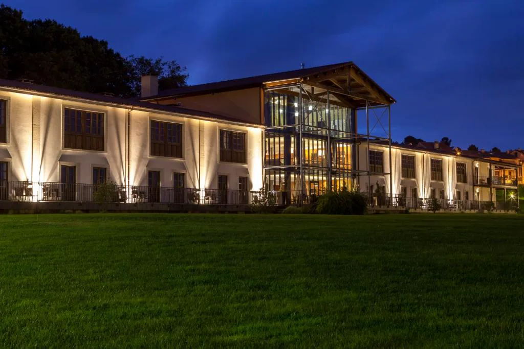 Fachada iluminada de noche junto al jardín, Eurostars Vila de Allariz Hotel Balneario