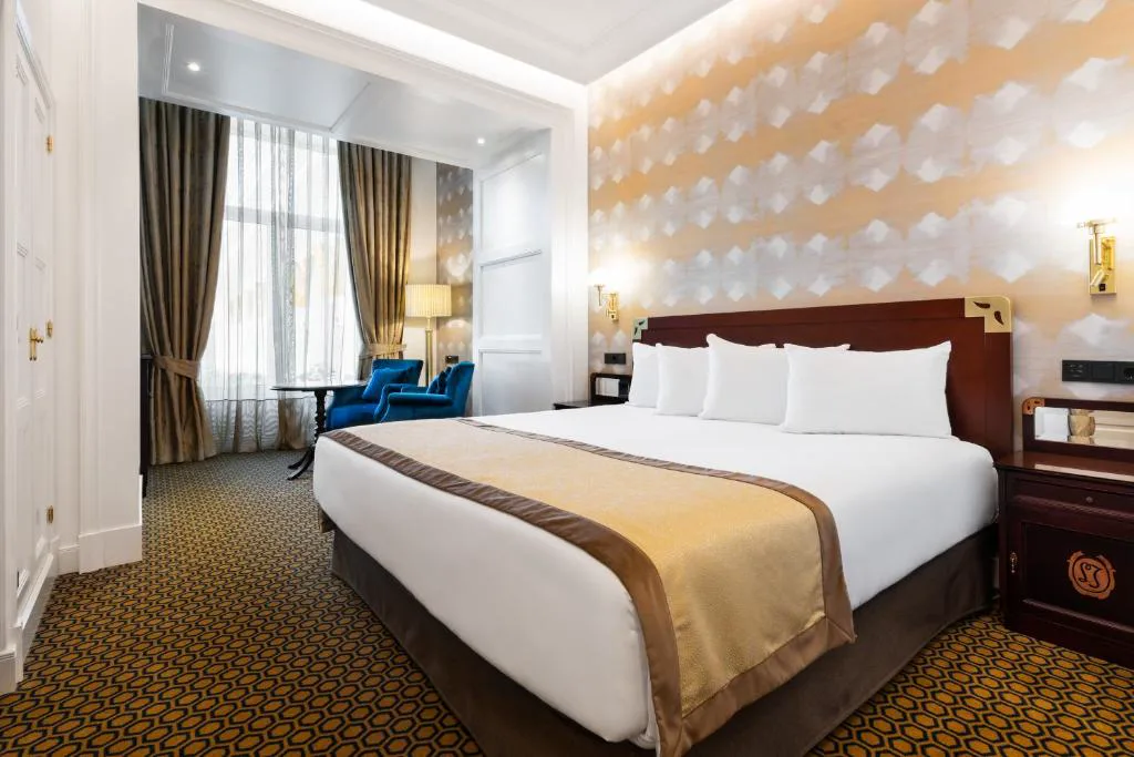 Dormitorio elegante con cabecero oscuro y ropa de cama dorada, Eurostars Gran Hotel La Toja