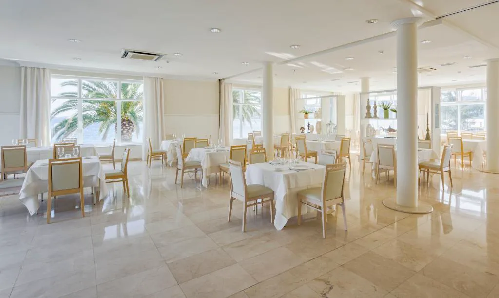Comedor del restaurante con grandes ventanales a la ría y palmeras, Eurostars Louxo Talaso