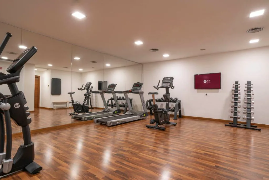 Gimnasio con máquinas de cardio en una sala luminosa