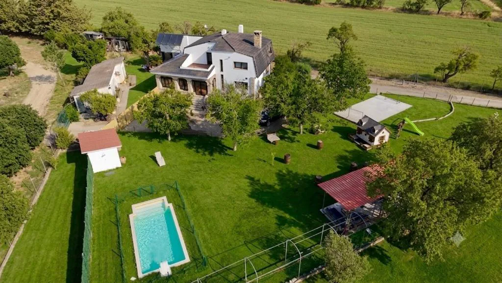 Vista aérea de la finca con piscina y jardín