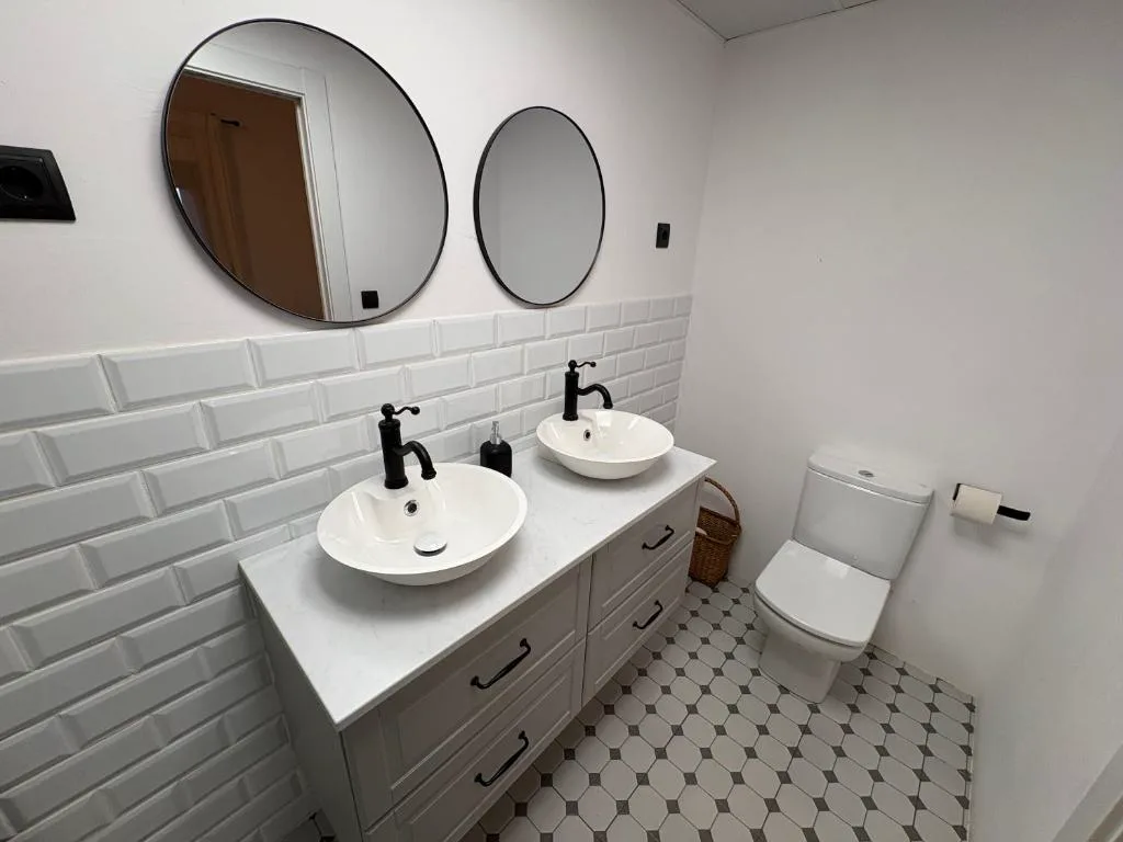 Baño con dos lavabos redondos y azulejos